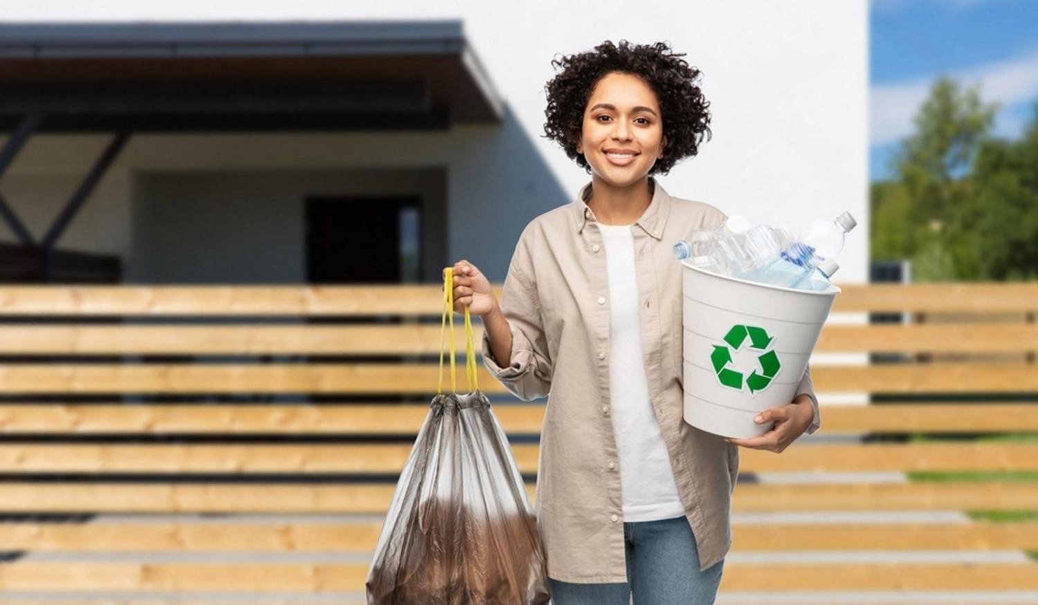 Woman outside a Dubai villa holding a recycling bin and rubbish bag after a home clean-up